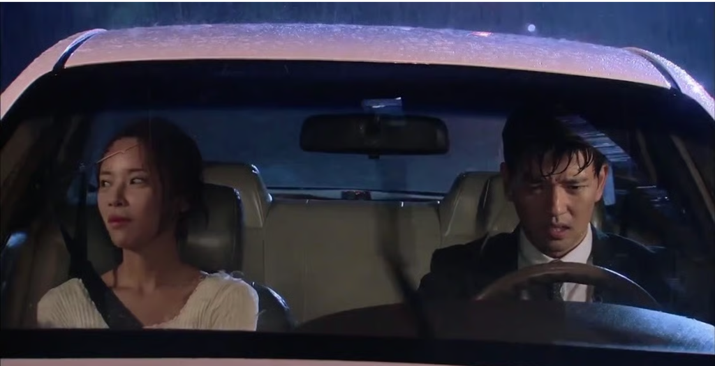 Hwang Jung-eum and Bae Soo-bin sitting inside a car during a heavy rainstorm in Secret Love (2013).